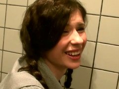 Two dicks are getting put inside a tiny woman in a public restroom