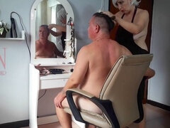 Aproned hairdresser in a naturist barbershop surprises client with a strip tease!