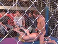 A undressed blonde is getting fucked in the ring in a large cage