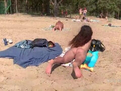Naked girl masturbates and pisses on a public nude beach