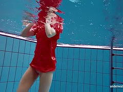 Pretty girl in red sexy open dress swimming