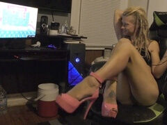 Hot gamer girl plays in sexy pink high heels, showing off her shaved pussy and long legs