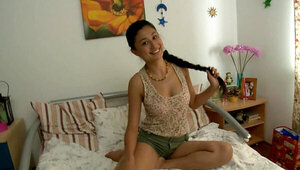 A pretty teen is smiling on the bed while she is making love