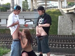 Cum in the mouth of a hot blonde teen girl in a public street sex threesome by a railway with 2 young guys doing blowjob cock sucking and vaginal pene