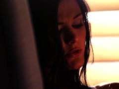 Babe with long dark hair stimulates pussy by the window