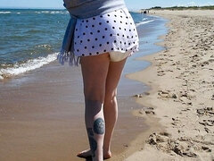 Nicole walks along the seashore in a wet diaper