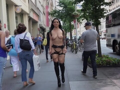 Kinky woman with large tits is walking naked around town