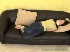 Asian gal bound and gagged on a couch
