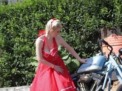 Nice-looking blonde enjoys posing next to a bike