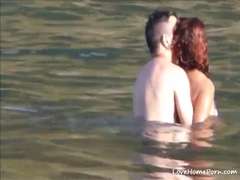 Horny couple having some fun in the water at the beach