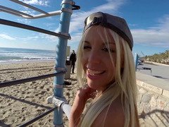 A blonde is on the beach, having sex in public with a horny dude