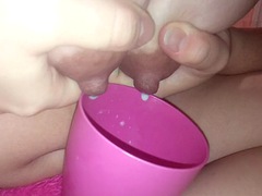 Young mom pours milk from breasts into a cup