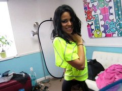 A Latina with an infectious smile is sucking a very large pole