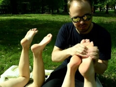 Two barefoot girls in park having their feet worshiped by a stranger (foot worship, public feet)
