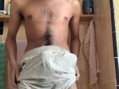 Hairy guy rubs himself, pees in shorts and cums afterwards