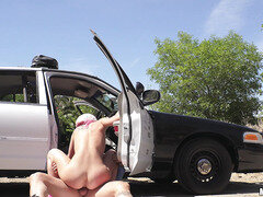 Teen Aidra Fox rides the cop by his car outdoors