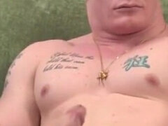 A Serious Man in a Tattoo Caresses His Bolt While Sitting on the Couch