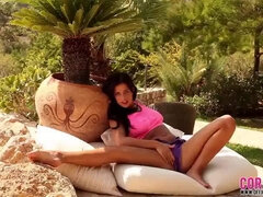 Seducing brunette with naked boobs Coral May is staying back to the camera