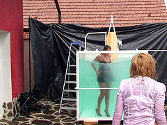 black-haired Dunk Tank Wetlook in dark-hued dress