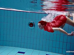 Pretty girl in red sexy open dress swimming