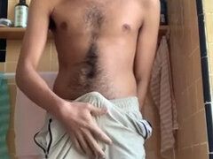 Hairy guy rubs himself, pees in shorts and cums afterwards