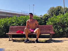 A man with a perfect body naked on a public bench