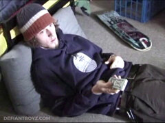 Adam relaxes on the floor watching porn video, strokes cock, plays with butthole, and blasts cum load onto skateboard