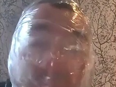 Breathing play with cling film in latex catsuit