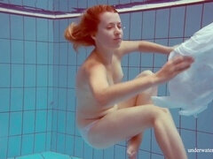 Busty redhead Melisa Darkova flaunts her ample caboose while swimming