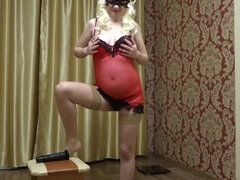 The blonde with a pregnant tummy in a red peignoir fucks hairy pussy to orgasm.