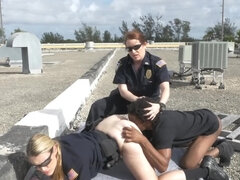 Black stud and two female cops are fucking on the roof