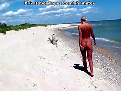 A couple of nudism lovers hardly pairing off on the sand