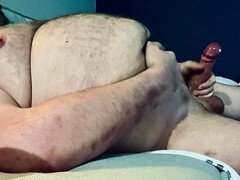 Big daddy gets frisky stroking his thick uncut cock on the sofa