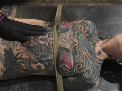 Tattooed wench is tied up and fingered in the BDSM room