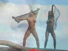 Two girls are on the beach and they are dancing around nude well