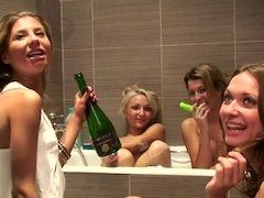 Naked champagne drinking friends look good in the bathtub