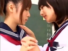 2 Schoolgirls Kissing Patting While Standing In The Classroo