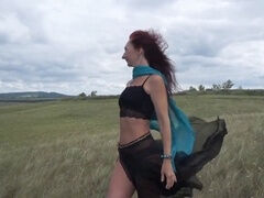 Mature exotic dancer enjoys windy weather atop a hill in Russia