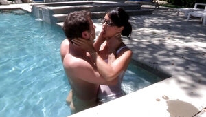 A girl kisses her lover in the pool and she makes him cum