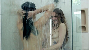 Two girls are in the shower and they are kissing one another