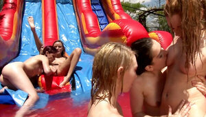 Girls are fucking each other at a water slide in a hot orgy.