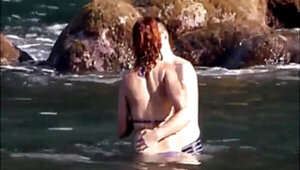 Horny couple having some fun in the water at the beach