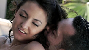 Two people enjoy one another's company by the pool outdoors