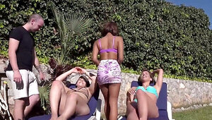 Three girlfriends sunbathe and fight for a cock on a beach