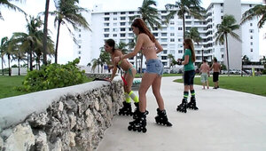 Girls on roller skates fool around with each other in the room