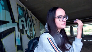 Glasses girl strokes that dick and takes it under the bridge