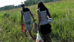 Two cocks are getting sucked on a picnic in the grass in a threesome