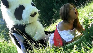 Guy in a panda suit is penetrating a busty woman in the field