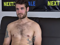 An athlete with a tattooed body at a casting solo jerks off during an interview