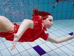 Glamorous kitten in red sexy open dress swimming